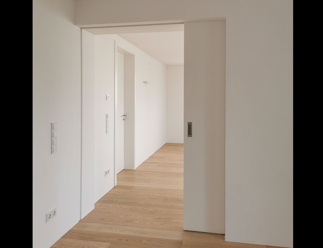Pocket door in modern hallway with herringbone floor